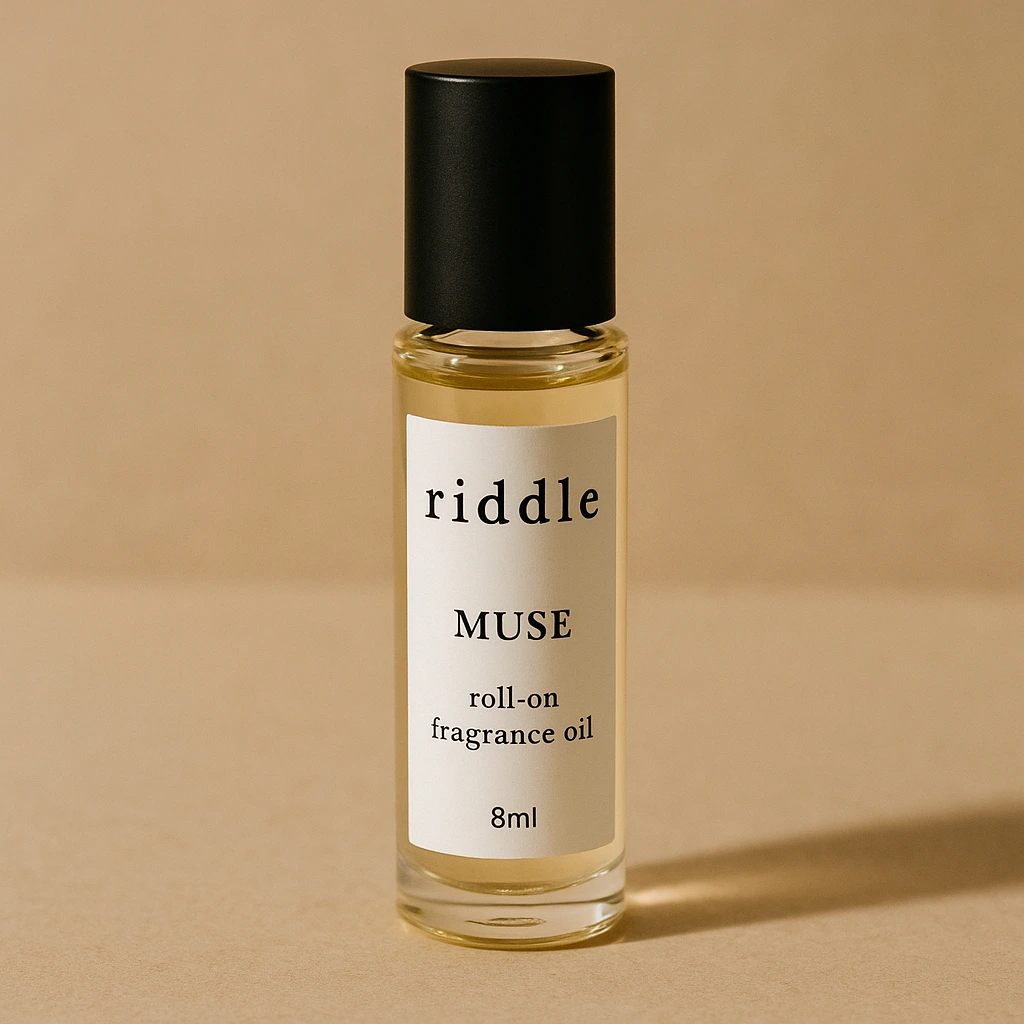 Riddle-style Muse 8ml roll-on fragrance oil on a vanity with florals.